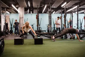 Middle-aged woman using reaction lights to improve agility in a gym setting