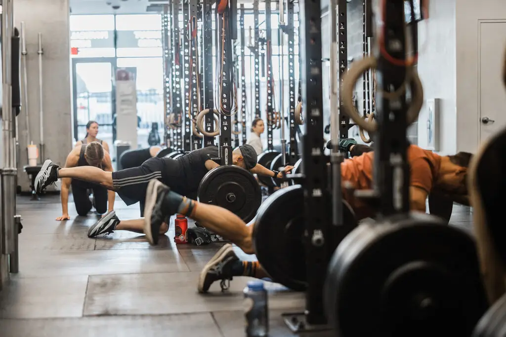 A group of adults performing the bird dog exercise in a strength class