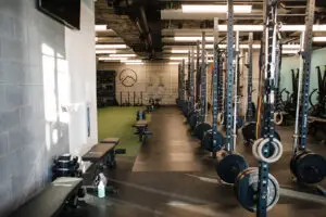 Row of squat racks alongside 40 feet of indoor turf at EVOLVE Flagstaff gym