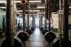 Row of freestanding squat racks down the center of EVOLVE Flagstaff gym