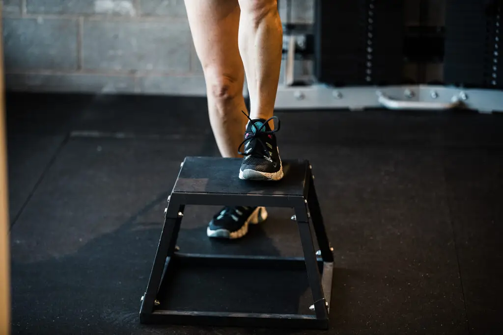 Close-up of legs performing a step-up onto a 12-inch box.