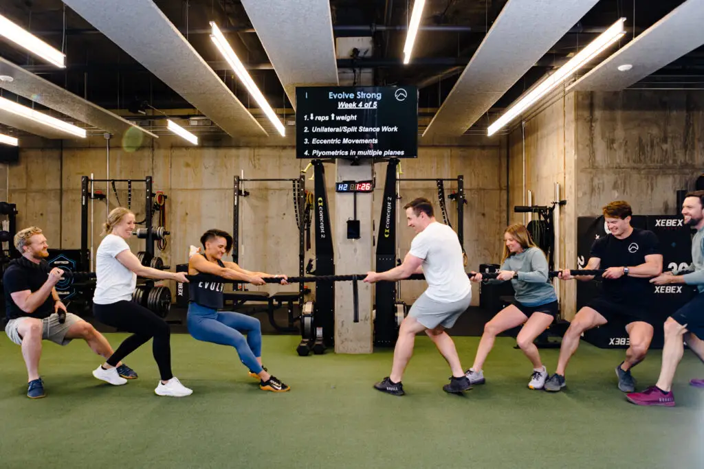 EVOLVE Flagstaff staff playing tug of war on indoor gym turf